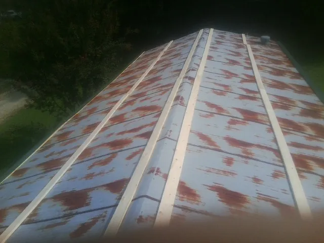 Rusted metal roof panels with new wood purlins before replacement — Storm Damage Roof Repair in Bluff City by Roofing Brothers