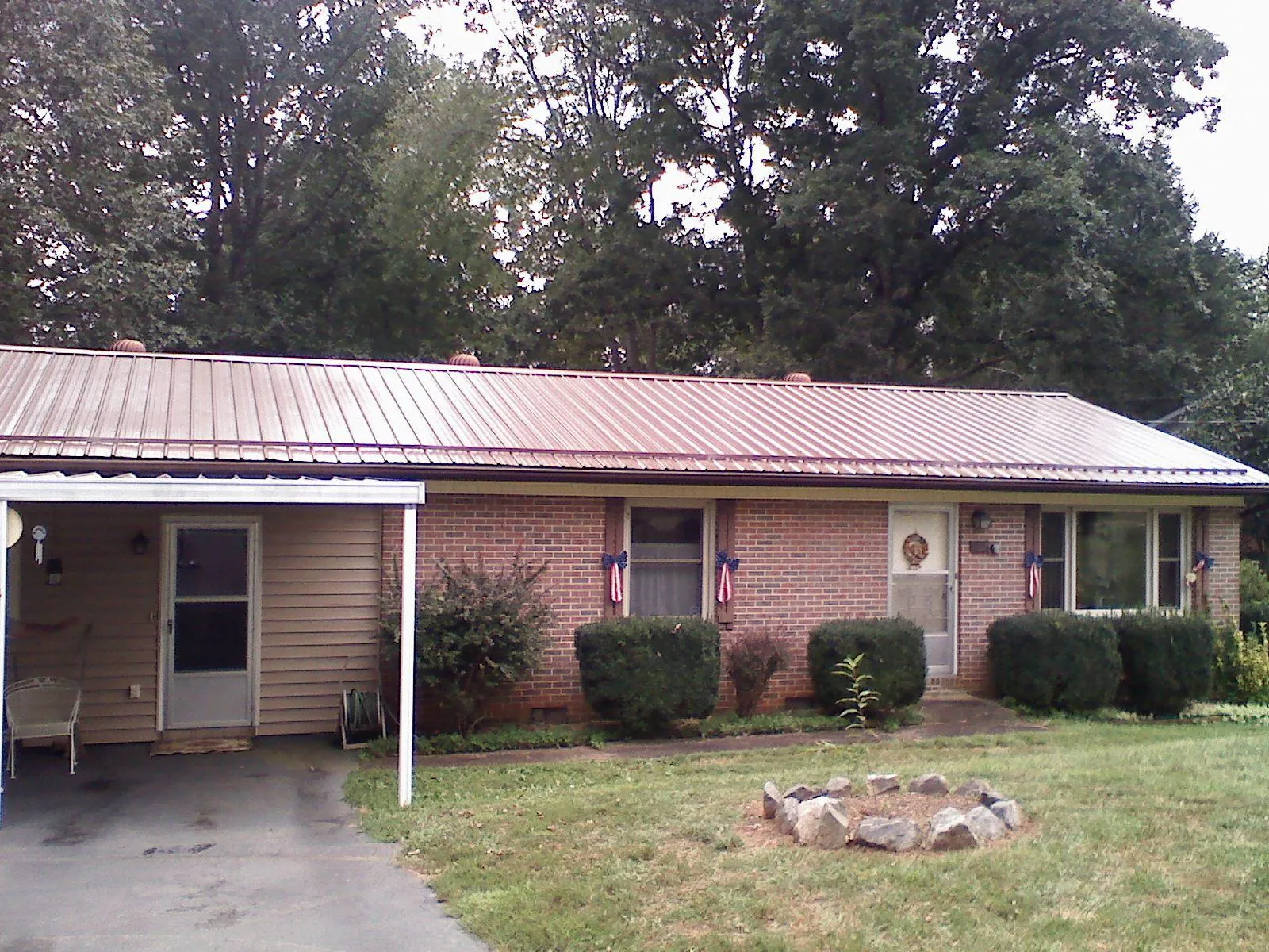 Bronze metal roof and carport on a brick ranch home — Roof Repair work by our crew in Bluff City